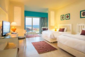 马特鲁港凯撒湾度假酒店的酒店客房设有两张床和电视。
