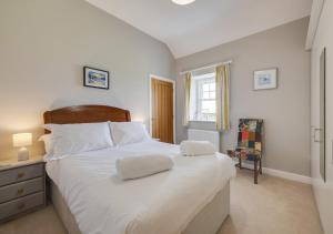 EllinghamThe Barns的卧室配有一张白色大床和两条毛巾