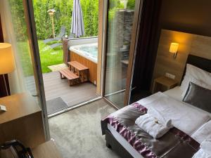 凯斯特海伊Villa Aruba & Private SPA Suites的一间卧室配有一张床和一个配有浴缸的阳台