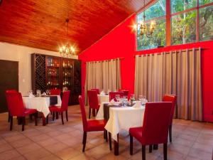 白河Hotel 247 @ White River的一间设有桌椅和红色墙壁的餐厅