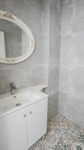 厄吕代尼兹萨隆尼卡套房酒店的浴室设有白色水槽和镜子