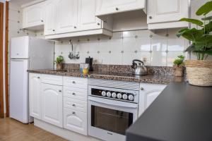 埃斯塔蒂特RVHotels Apartamentos La Pineda的厨房配有白色橱柜和白色冰箱。