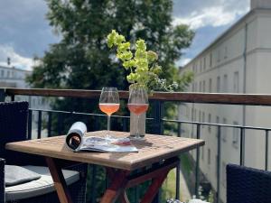 罗斯托克The Green Rostock Apartment Hotel的一张桌子,上面放着两杯葡萄酒和一本书