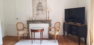 莫内斯捷Domaine et Manoir du Picaud的客厅配有电视和桌椅