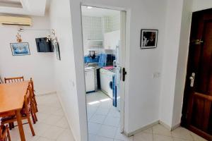 拉巴特Élégant appartement 3 chambres的厨房设有一扇门,可通往带桌子的厨房