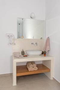 阿斯提帕莱亚镇Ihthioessa Boutique Hotel的浴室配有盥洗盆、镜子和毛巾