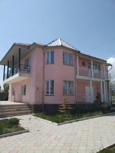 博斯特里Пансионат Сабрина的粉红色的房子,上面设有阳台