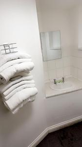 纽波特Hotels 24-7 - The Old Victoria Hotel的白色的浴室设有水槽和白色毛巾。