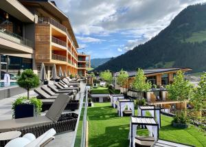 格罗萨尔DAS EDELWEISS - Salzburg Mountain Resort的一个带躺椅和草坪的酒店阳台
