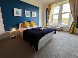 佩斯利A Spacious Flat with Character - Private Car Space的一间卧室设有一张蓝色墙壁的大床