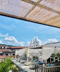 瓜杜阿斯Matisia Hotel Boutique的屋顶上带椅子和遮阳伞的甲板
