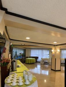 安巴托Hotel De Las Flores的大房间,桌子上摆着杯子和盘子