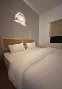 安曼Crafthouse的一间卧室配有两张带白色床单和灯的卧室