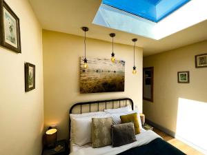 赫彻姆Norfolk Accommodation的卧室配有一张床,墙上挂有绘画作品