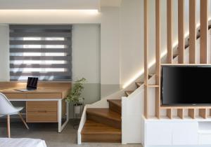 萨尔蒂Exclusive Villas Pappas的客厅设有楼梯、电视和书桌