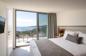 萨尔蒂Exclusive Villas Pappas的一间卧室配有一张床,享有海景
