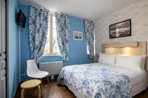 滨海利翁海狮酒店的卧室拥有蓝色的墙壁,配有一张床和椅子