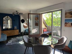 斯特拉斯堡Spacieux loft en duplex的客厅配有玻璃桌和椅子
