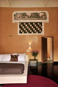 库斯科卡萨卡塔赫纳精品酒店及水疗中心的一间卧室配有一张床和一面 ⁇ 形墙