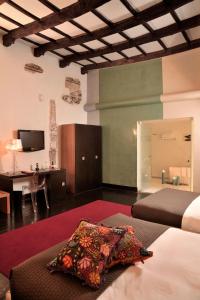 库斯科卡萨卡塔赫纳精品酒店及水疗中心的一间卧室配有两张床、一张桌子和一台电视。