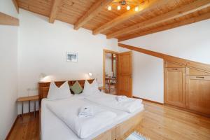 布尔古斯奥Ferienwohnungen Zwick Valarga的一间卧室配有白色床单和木制天花板。