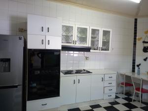 开普敦Guest Houses Great choice的厨房配有白色橱柜和炉灶烤箱。