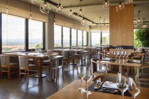布朗库堡Meliá Castelo Branco的餐厅设有木桌、椅子和窗户。