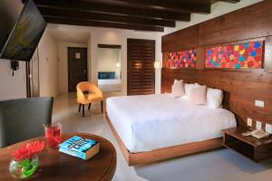 普拉亚卡门Soul Beach Boutique Hotel & Spa的卧室配有一张白色的大床和一张桌子