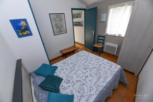 圣吉尔-克鲁瓦德维GÎTE DES FRUCHES的小卧室配有带蓝色枕头的床