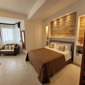 Bisaccia多莫斯洛穆列亚酒店的一间卧室,卧室内配有一张床和一把椅子