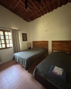 科尔多瓦Rancho tres Marías的一间卧室设有两张床和窗户。