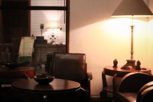 日惹格拉哈吉纳斯赫科塔巴鲁酒店的一间设有桌子、灯和椅子的房间