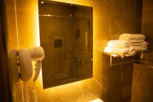 都拉斯Hotel Vila Mare的浴室设有镜子、电话和毛巾