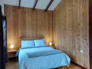 CopeyCuruba Lodge的一间卧室配有一张带木墙的大床
