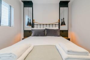 伦敦The Balham Hideaway的卧室配有一张带白色床单和枕头的大床。