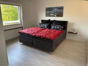 埃德湖Ferienwohnung Zum Wildpark的一间卧室配有一张带红色毯子的大床