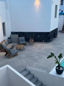莫诺利索斯Noir Santorini的带沙发和盆栽植物的客厅