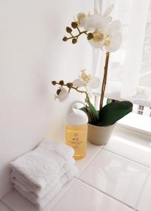 凯西克多切斯特楼酒店的白色的浴室,在柜台上配有毛巾和鲜花