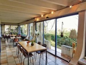 罗纳河畔的图尔农Casa mARTa : Suites, terrasses et vue panoramique的餐厅设有桌椅和大窗户。