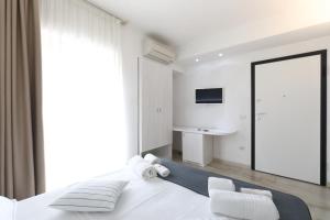 梵蒂冈角拉尔可巴利诺度假酒店的卧室配有一张白色大床和镜子