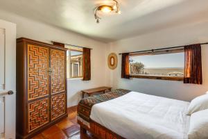 El PradoAdobe Escape with Hot Tub and Art for Sale!的一间卧室设有一张大床和一个窗户。