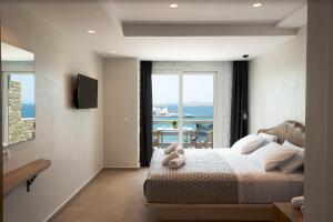 米克诺斯城Magic View Suites Mykonos的一间卧室设有一张床,享有海景