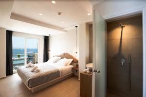 米克诺斯城Magic View Suites Mykonos的一间卧室配有一张床,浴室设有淋浴。