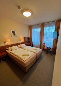 埃格尔艾斯特拉高级酒店的酒店客房设有床、桌子和电视。