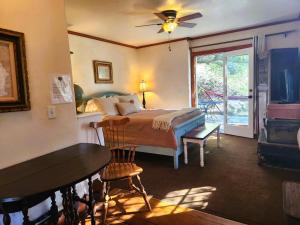 朱利安Oak Hill Inn的一间卧室配有一张床、一张桌子和一个窗户。