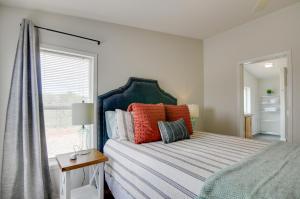 埃斯卡兰特Utah Retreat - Hot Tub, Deck and Near National Parks的一间卧室配有一张带色彩缤纷枕头的床和窗户。