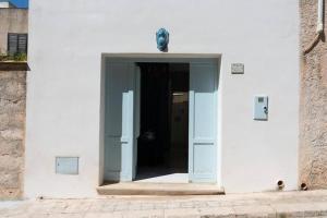 法维尼亚纳Gioiello a due passi dal CENTRO的通往白色建筑的门廊,有门