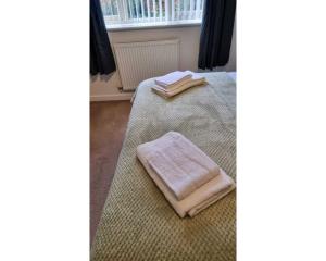 曼斯菲尔德No7的一间卧室配有两张带毛巾的床