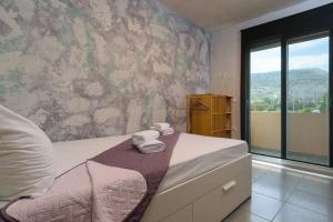 MourniaíKonstantinos , luxury maisonette in Chania的一间卧室配有带毛巾的床和窗户。