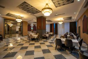 巴库Volga Hotel Baku的用餐室配有桌椅和吊灯。
